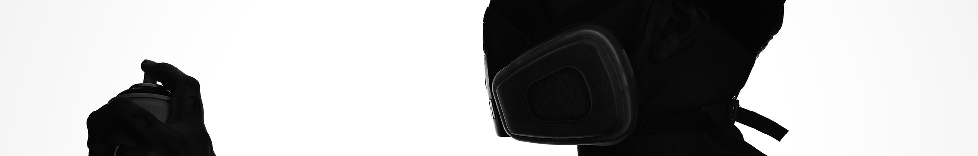 Black and white image of a person in profile wearing a respirator mask and holding a spray can.