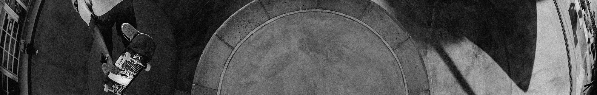 Black and white panoramic shot of Zach Miller skateboarding on a ramp.
