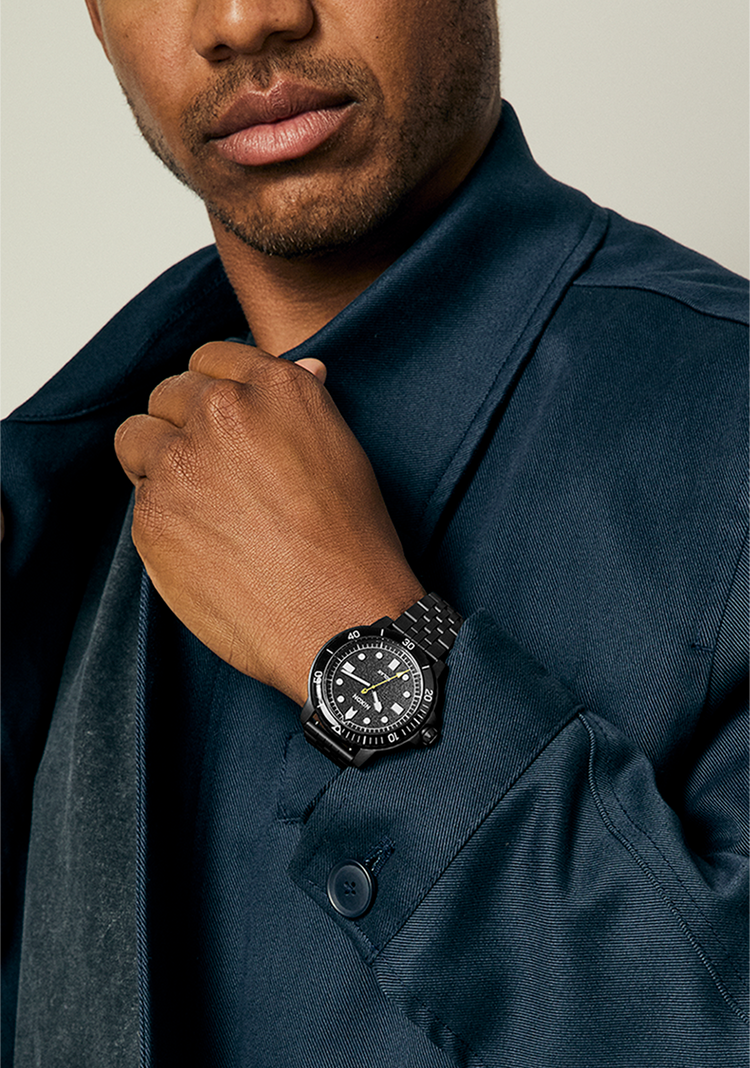Young man wearing a Nixon Stinger 44 watch in black.