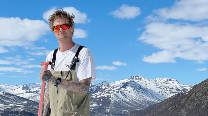Nixon team rider Mikkel Bang holding a shovel in the mountains