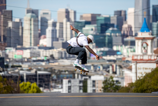 Zion Wright skateboards with a cityscape in the background