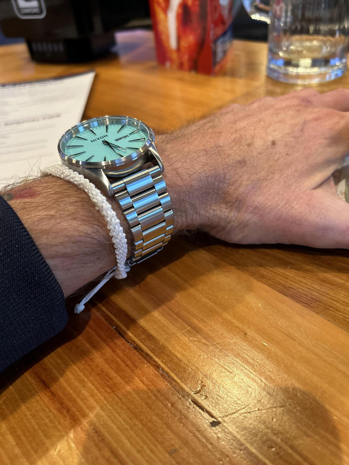 Man wearing a turquoise blue Nixon Sentry Stainless Steel watch