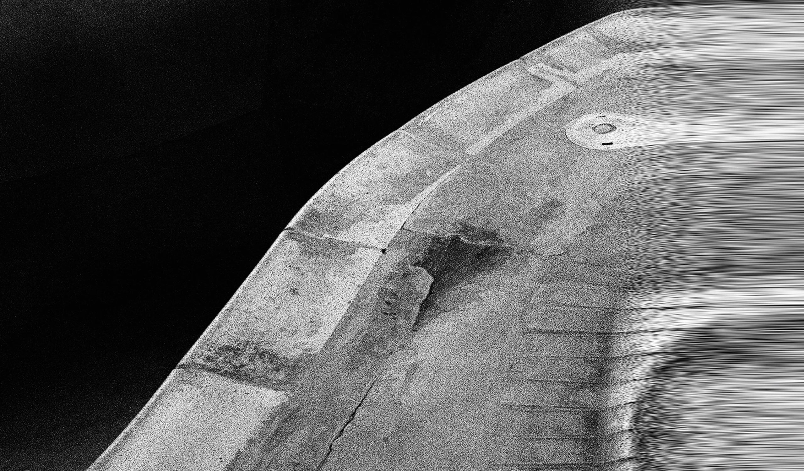 Black and white image of the edge of a skate pool blurred out. 