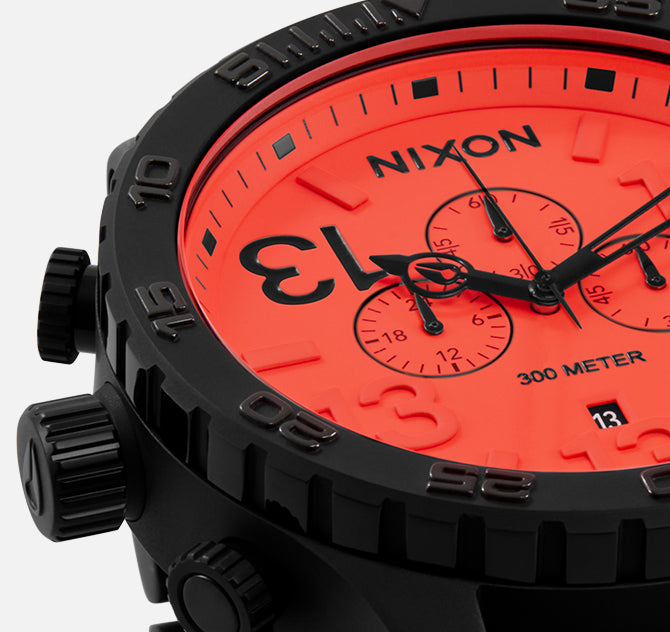 Nixon watch with a bright red face and black case on a white background