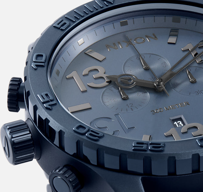 Nixon watch with blue case and face, close-up view.