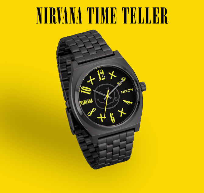Black Nixon Nirvana Time Teller watch with yellow numbers and iconic smiley face logo on a yellow background.